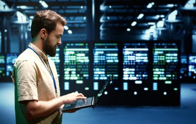 Developer checking event logs and diagnostic tools to identify server issues root cause. Programmer using laptop to check supercomputer operating system configuration settings